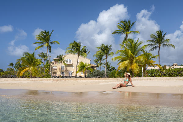 Girl sunbathes on the beach facing the turquoise water of the Caribbean sea, Heywoods Beach, Barbados Island, Lesser Antilles, West Indies, Caribbean region 
