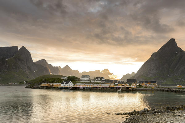 Midnight sun on the fisherman village frames by rocky peaks and sea Sakrisoya, Nordland county, Lofoten Islands,Northern Norway, Europe