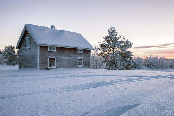 Wooden house in the snowy forest, Kiruna, Norrbotten County, Lapland, Sweden, Europe