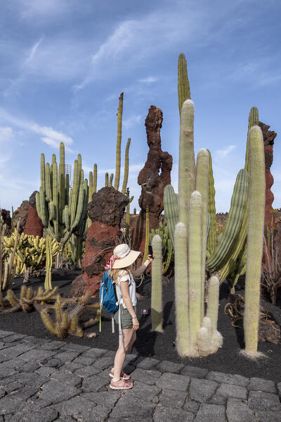 Girl makes a selfie at the Jardin de Cactus, garden designed by Cesar Manrique in Lanzarote, Lanzarote, Canary Island, Spain, Europe
