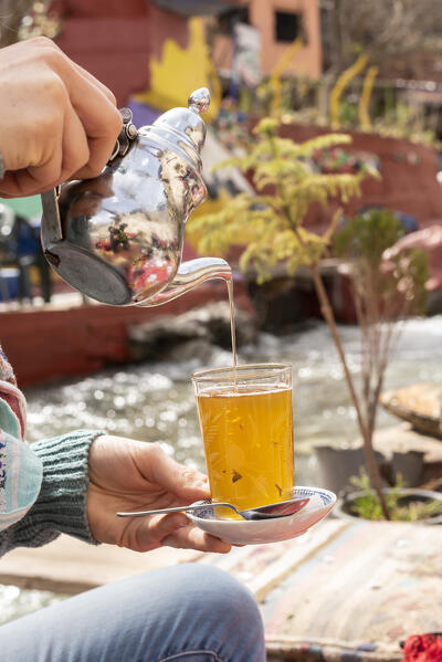 The typical Moroccan tea poured along the banks of the Ourika river at the small village of Sti Fadma in the mountains of Morocco, Morocco, Africa 