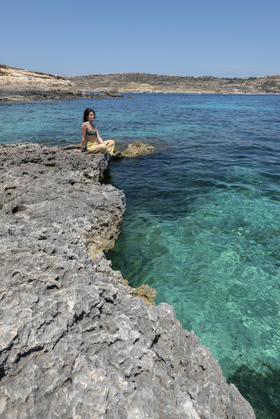 Beautiful girl admires Blue Lagoon of Comino Island, Malta, Europe