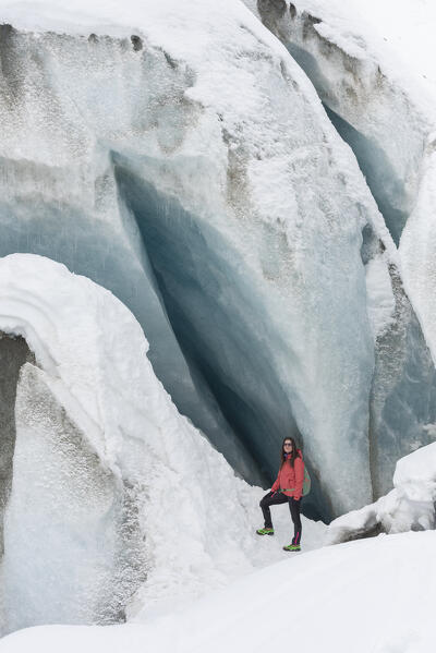 Beautiful girl near the cave of Morteratsch glacier, Morteratsch, Engadine, canton of Graubunden, Switzerland
