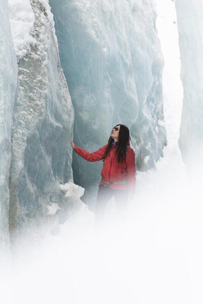 Girl admires the beauty of the ice of Morteratsch glacier,Morteratsch, Engadine, canton of Graubunden, Switzerland