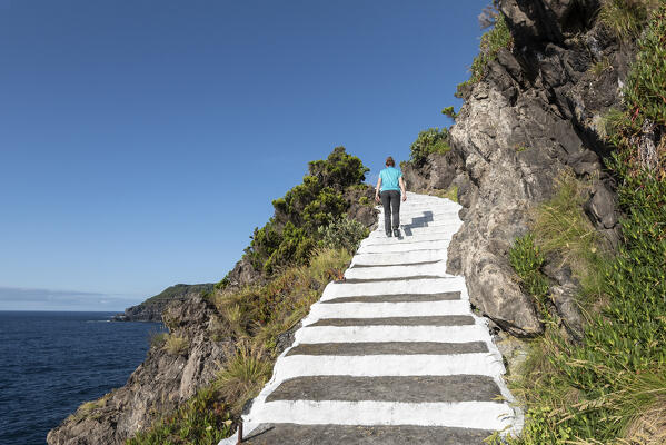 Girl on the steps along the cliff, Terceria island, Azores islands, Portugal