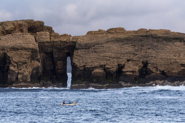 Fisherman on the boat in front of the rock in the middle of the ocean, Azores, POrtugal, Europe