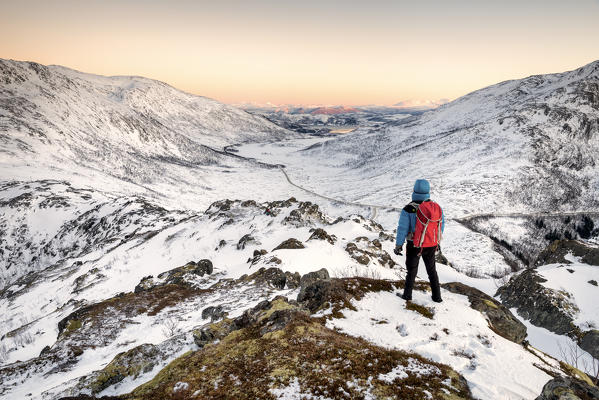 Hikers watch the artctic landscape during the sunset, Mefjorden, Senja, Norway, Europe.