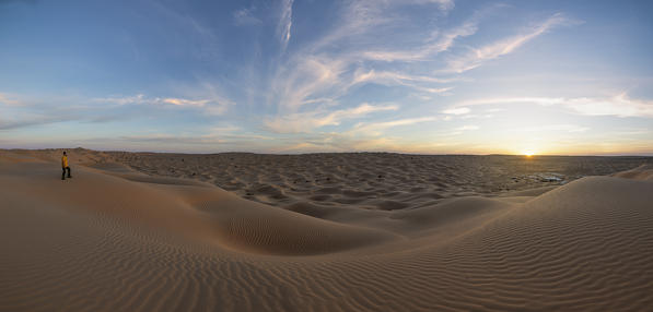 one person admiring the sunset around Camp Mars village in the sand dunes, Sahara desert, Tunisia, Northern Africa.