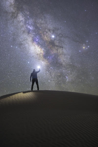 one person admiring the milky way in the sand dunes, Sahara desert, Tunisia, Northern Africa.