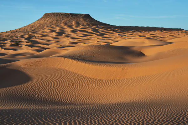 Sunset around Camp Mars village in the sand dunes with Tim Bejin mountain, Sahara desert, Tunisia, Northern Africa.