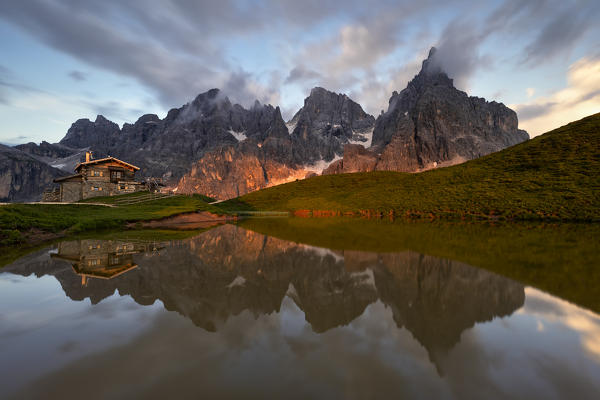 Enrosadira on Pale di San Martino Dolomites reflecting on the lake of Segantini hut, Rolle Pass, Trento province, Trentino Alto Adige, Italy