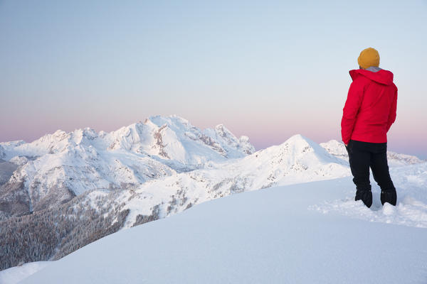 A hiker observes the panorama along the Giau, looking at the Marmolada Group, Dolomites, municipality of Cortina d'Ampezzo, Belluno province, Veneto district, Italy, Europe.
