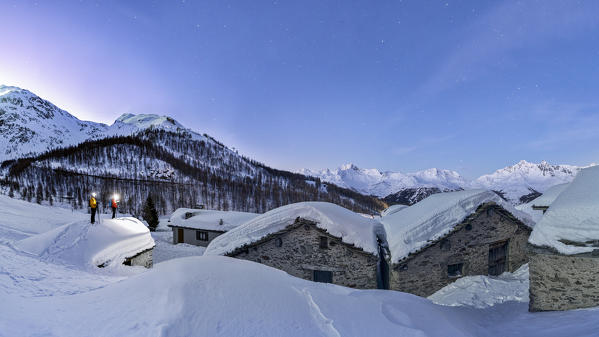 two photographers catch the dawn in the village submerged by the snow, Groppera, Valtellina, municipality of Madesimo, Sondrio province, Lombardia district, Italy, Europe.