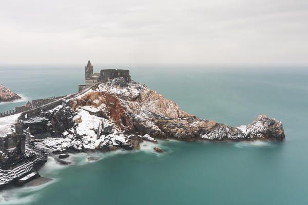 during a cold winter, the snow falls on the seashore, covering the iconic church of San Pietro, Unesco World Heritage Site, municipality of Porto Venere, La Spezia province, Liguria district, Italy, Europe