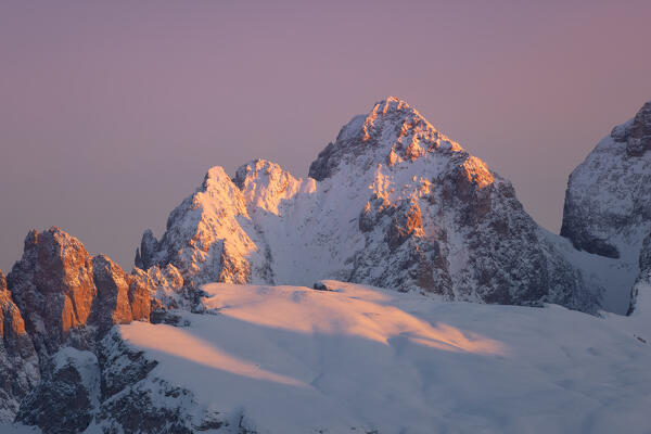 a ray of warm light envelops the peaks of Puez-Odle mountain during a cold winter sunrise, Dolomites, Bolzano province, Italy, Europe