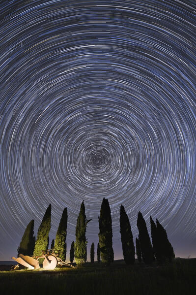 the rotation of the stars around Polaris, near the iconic Cypresses of San Quirico d'Orcia, Siena province, Tuscany district, Italy, Europe