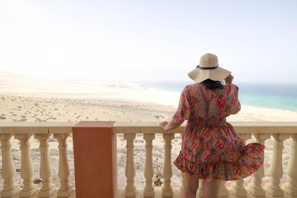 a tourist admires the view from the balcony, near to Playa de Sotavento during a sunny summer day, Fuerteventura, Canary Island, Spain, Europe