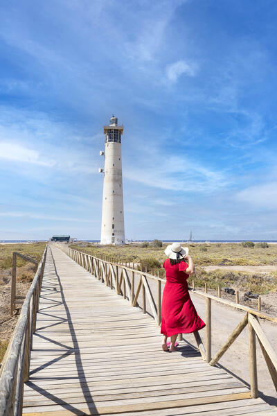 a tourist admires the view near the Morro Jable lighthouse during a sunny summer day, Fuerteventura, Canary Island, Spain, Europe