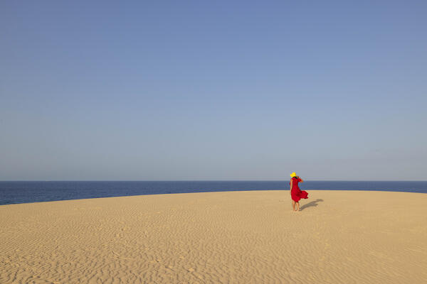 a tourist admires the view at dunes of Natual Park of Corralejo, Fuerteventura, Canary Island, Spain, Europe