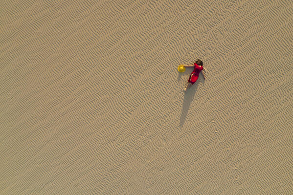 one girl enjoys the sunset on the desert dune in Natural Park of Corralejo, Fuerteventura, Canary Island, Spain, Europe