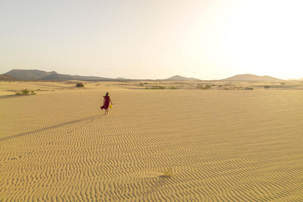a tourist admires the view at dunes of Natual Park of Corralejo, Fuerteventura, Canary Island, Spain, Europe