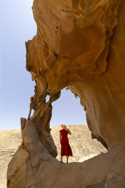 a tourist admires the view from the cave at Vega de Rio Palma during a sunny summer day, Fuerteventura, Canary Island, Spain, Europe