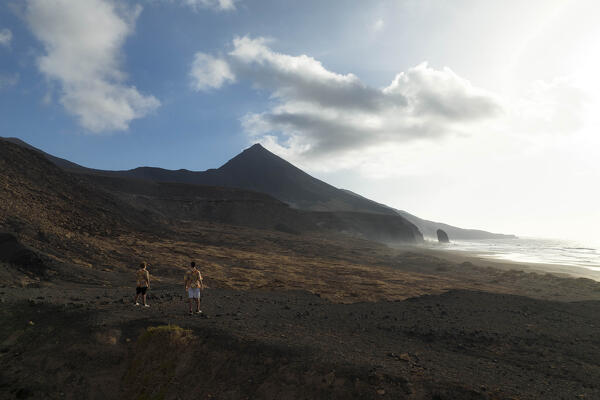two guys admiring the beautiful landscape near to Cofete beach during a summer day, Natural Park de Jandia, Fuerteventura, Canary Island, Spain, Europe