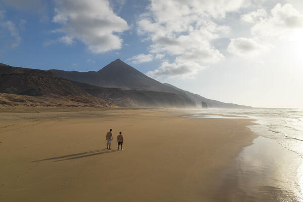 two guys admiring the beautiful landscape near to Cofete beach during a summer day, Natural Park de Jandia, Fuerteventura, Canary Island, Spain, Europe