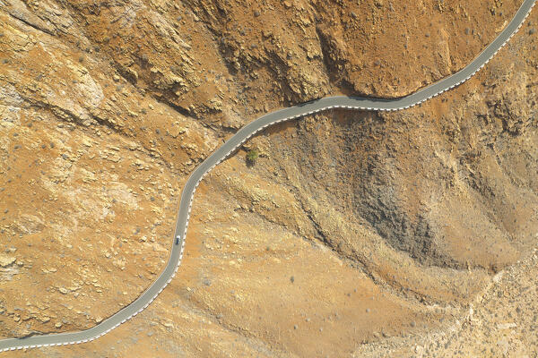 aerial vertical view taken by drone of one car driving along the road to the Fuerteventura mountain , Fuerteventura, Canary Island, Spain, Europe