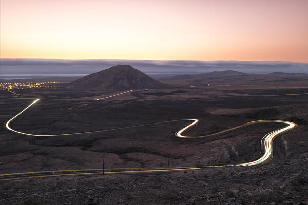 a long exposure to capture the car trails during a summer sunset along the road near to Tindaya mountain, Fuerteventura, Canary Island, Spain Europe