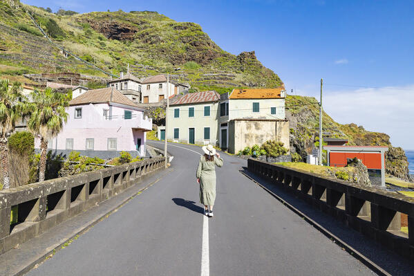 A girl enjoys the beautiful view from the bridge near the Praia da Ribeira da Janela beach during a spring day, Porto Moniz, Madeira Island, Portugal, Europe