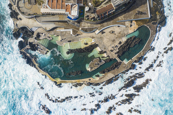 Vertical aerial view of the natural pools located in the city center of Porto Maniz during a spring day of rough seas, Porto Moniz, Madeira, Portugal, Europe