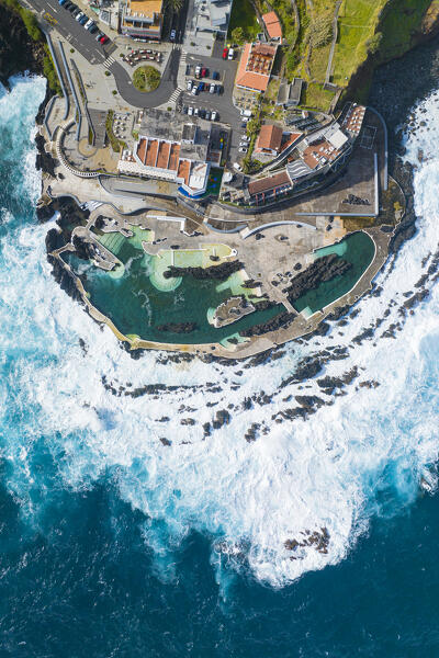 Vertical aerial view of the natural pools located in the city center of Porto Maniz during a spring day of rough seas, Porto Moniz, Madeira, Portugal, Europe