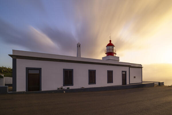 a warm light envelope the beautiful Farol da Ponta do Pargo during a spring sunset, Madeira, Portugal, Europe