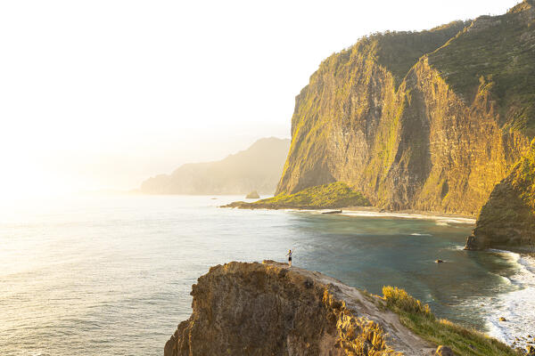 a girl admires the beautiful spring sunrise in Miraodouro do Guindaste, Madeira, Portugal, Europe (MR)