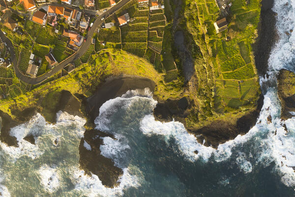 Aerial view taken from a drone of the coast of Seixal during a spring sunrise with warm enveloping light, Madeira, Portugal, Europe