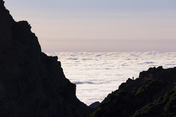 an hiker rests along a mountain path near Pico do Arieriro during a spring sunset, Madeira, Portugal, Europe