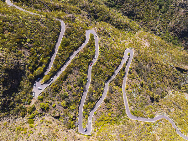aerial view taken from the drone of cars driving along one of the winding mountain roads during a sunny day, Tenerife, Canary Island, Spain, Europe