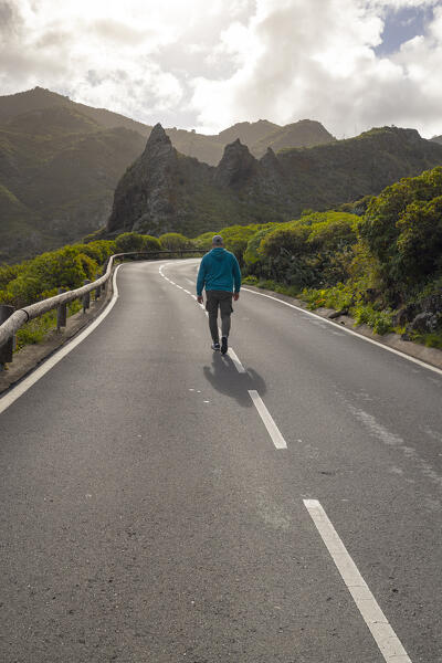 a man walking in the beautiful mountain road during a spring sunny day, whit a mountain in background, Tenerife, Canary Island, Spain, Europe