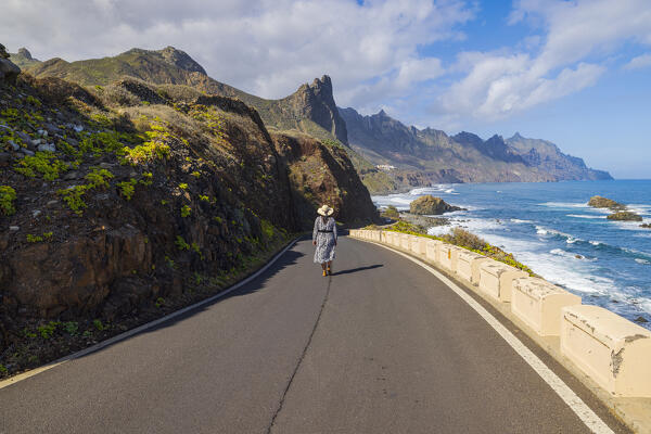 a woman walking in the beautiful coastal road near to the famous beach of Benijo during a sunny spring day, Tenerife, Canary Island, Spain, Europe