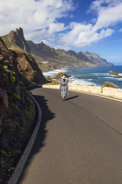 a woman walking in the beautiful coastal road near to the famous beach of Benijo during a sunny spring day, Tenerife, Canary Island, Spain, Europe