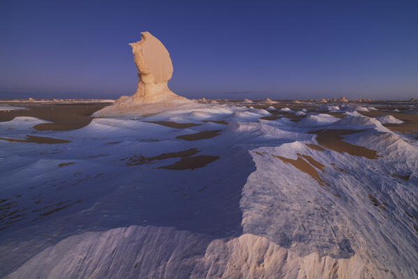an incredible light preceding the blue hour illuminates the spectacular rock formations of the White Desert landscape, during a beautiful winter day