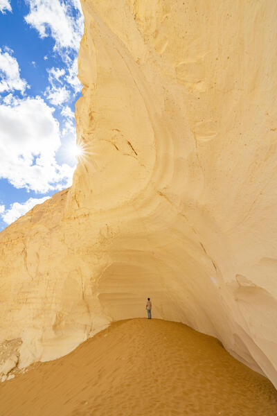 a boy admires the beautiful rock formations of the White Desert on a sunny day, White Desert, Egypt, Africa