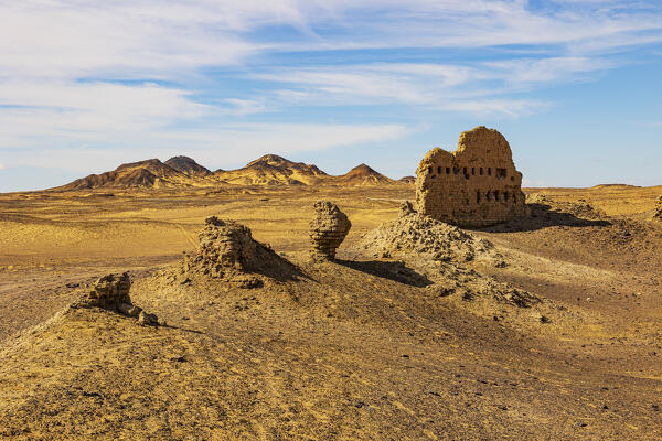 the hot sun illuminates the ruins of an old desert village in the Black Desert, Egypt, Africa