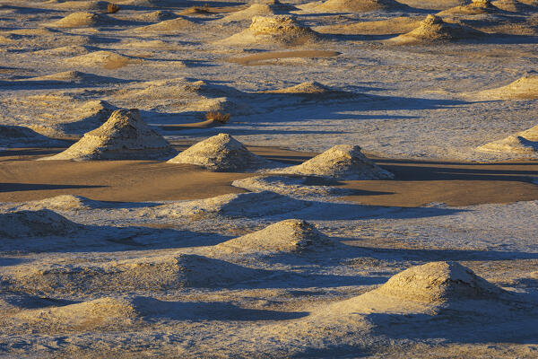 The first rays of the sun illuminate the spectacular rock formations of the incredible landscape of the White Desert, during a beautiful winter day, Egypt, Africa
