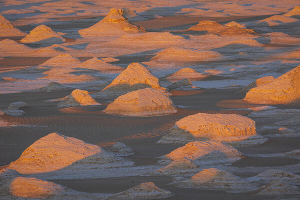 an incredible light preceding the blue hour illuminates the spectacular rock formations of the White Desert landscape, during a beautiful winter day