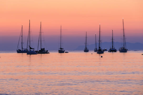 Pink sunrise over sailboats in the calm sea, Macinaggio, Cape Corse, Haute-Corse department, Corsica, France