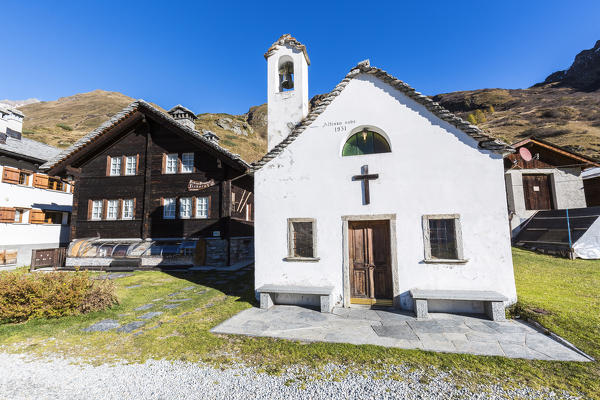 Traditional houses and church in the walser village of Riale, Val Formazza, Verbano Cusio Ossola province, Piedmont, Italy