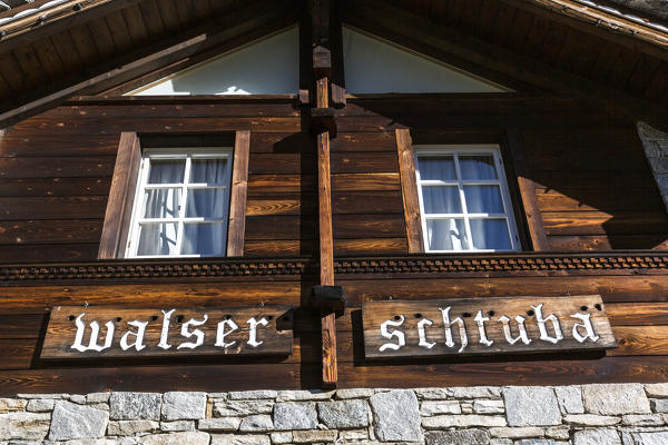 Windows and wood facade of the walser inn Schtuba in Riale village, Val Formazza, Verbano Cusio Ossola province, Piedmont, Italy