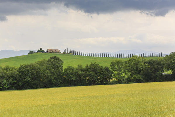 Italy, Tuscany, Orcia valley, dark clouds above farmhouse Poggio Covili at Castiglione d'orcia, province of Siena
